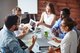 Group of people discussing at a table [Image by creator pressmaster from AdobeStock]