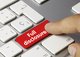 A person pressing a red "full disclosure" button on a keyboard with white keys [Image by creator momius from AdobeStock]